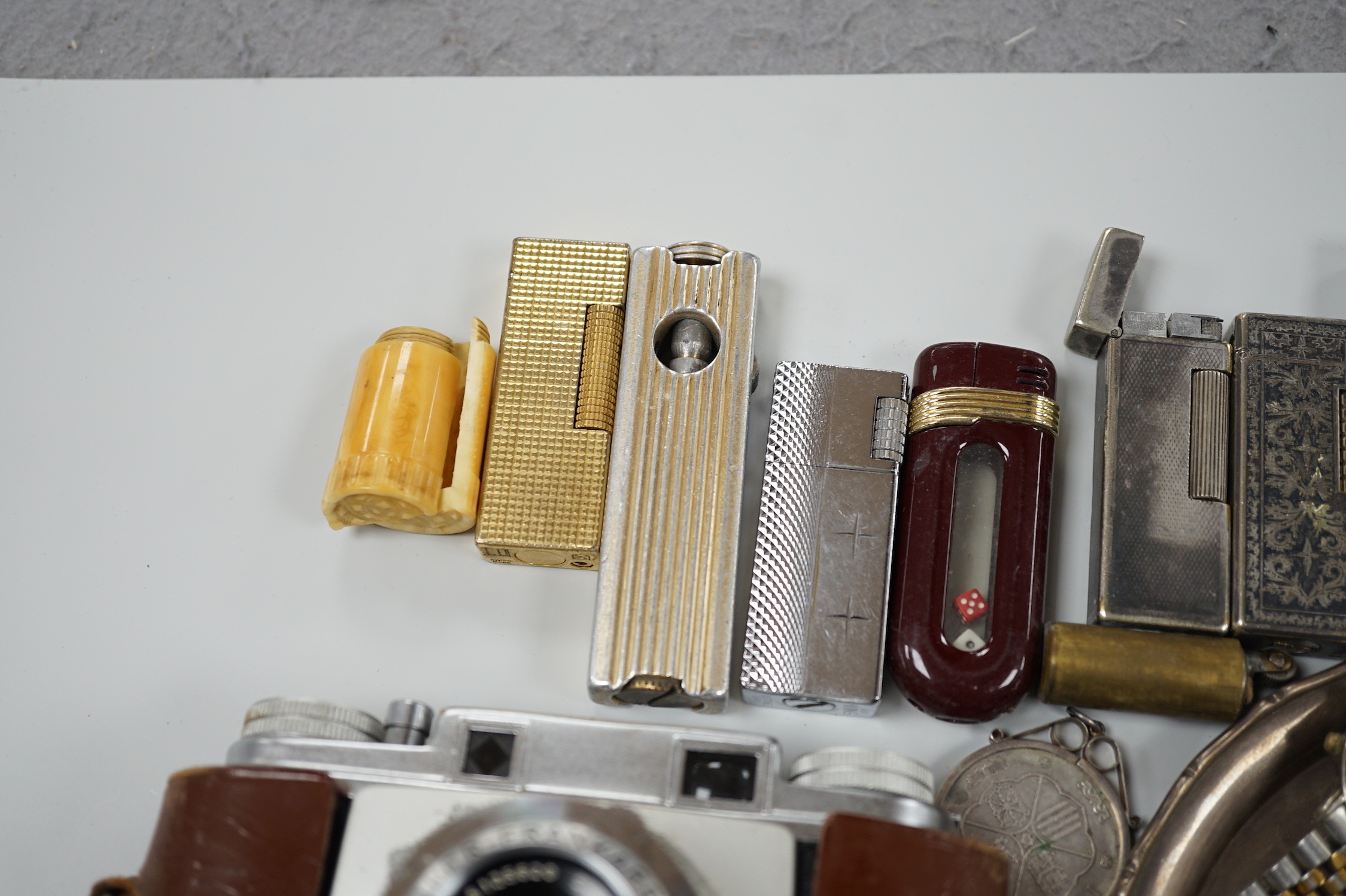 A collection of mixed wristwatches and cigarette lighters and a camera
